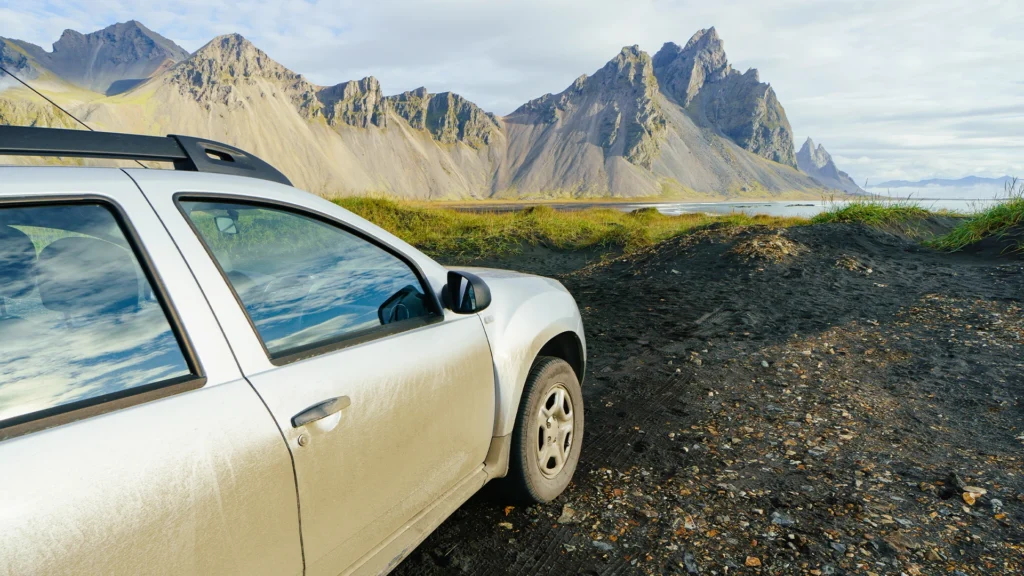 Coche de alquiler frente a las montañas durante un viaje por libre por Islandia