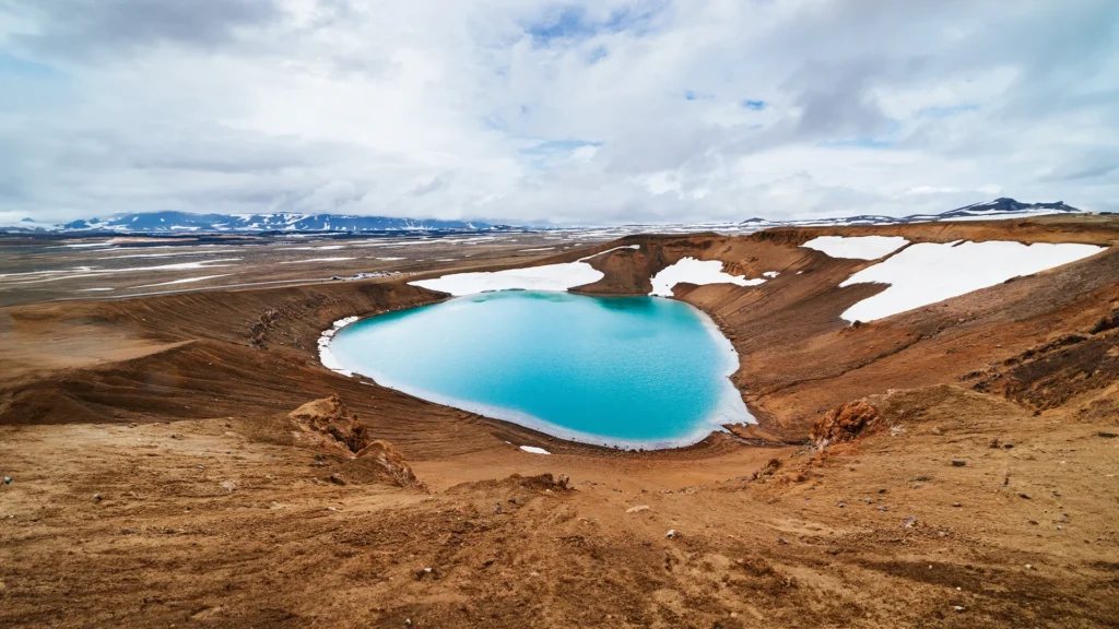 Cráter Víti en Krafla con lago turquesa y restos de nieve en el norte de Islandia