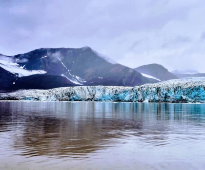 Lengua glaciar junto a una laguna en Islandia, con montañas al fondo.