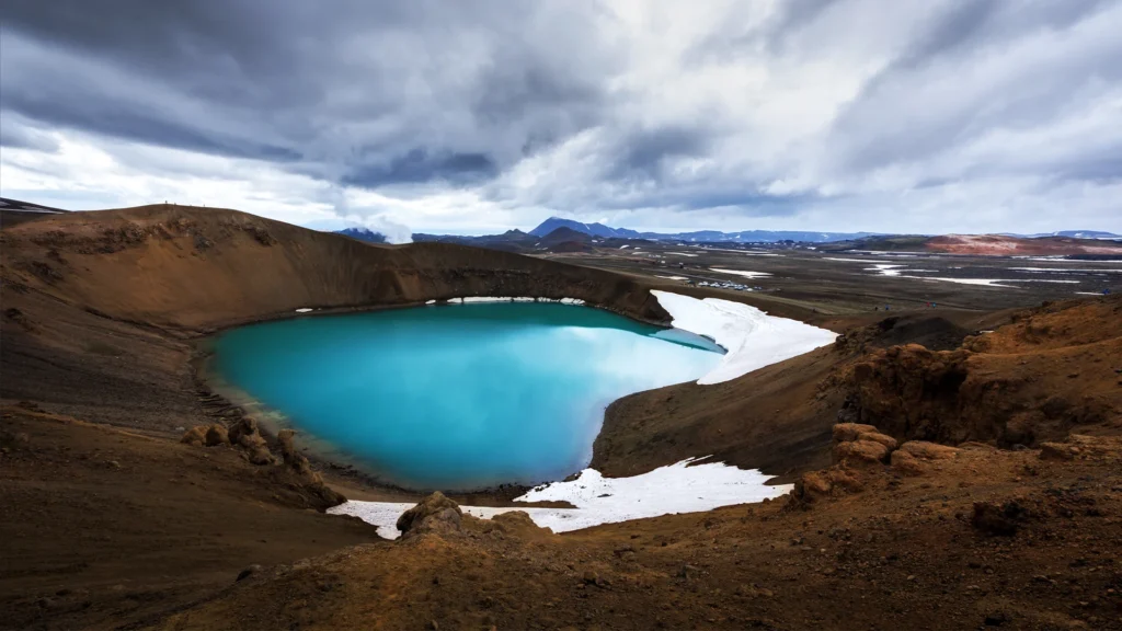 Lago azul del cráter Víti en Krafla con nieve y paisaje volcánico del norte de Islandia