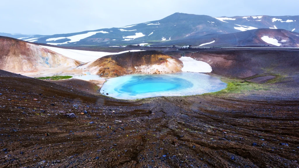 Zona geotérmica de Krafla con laguna azul, nieve y montañas volcánicas en el norte de Islandia