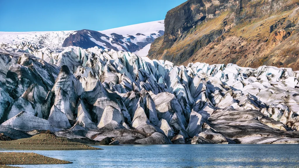 Frente glaciar de Skaftafell con grandes crestas de hielo junto a una laguna.