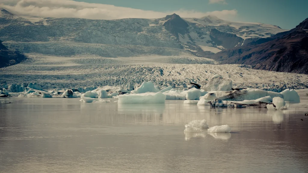 Laguna glaciar Jökulsárlón en Islandia, con grandes bloques de hielo flotando sobre el agua y el glaciar Breiðamerkurjökull al fondo.